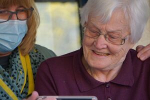 Elderly Senior Woman looking at phone, researching assisted living websites